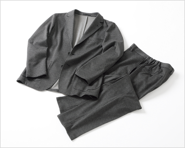 スーツを着ながらソファに寝転ぶ様子